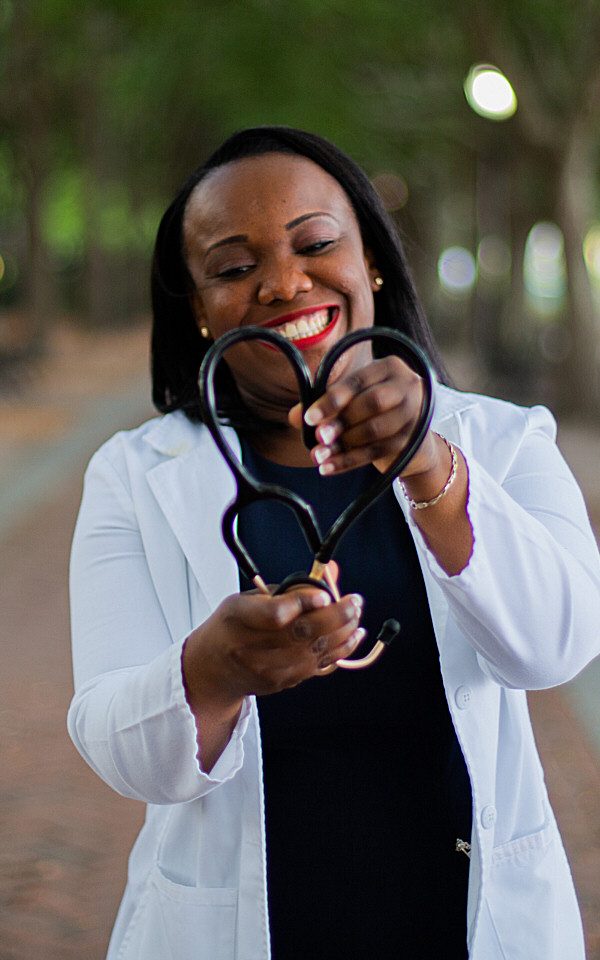 Female doctor bending rubber tube of stethoscope into a heart shape