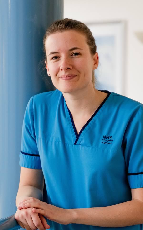 Young member of NHS staff in blue uniform